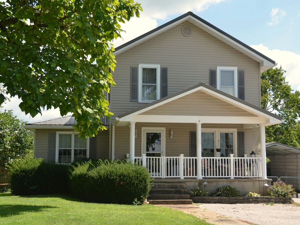 A two-story home with a welcoming front porch and green lawn